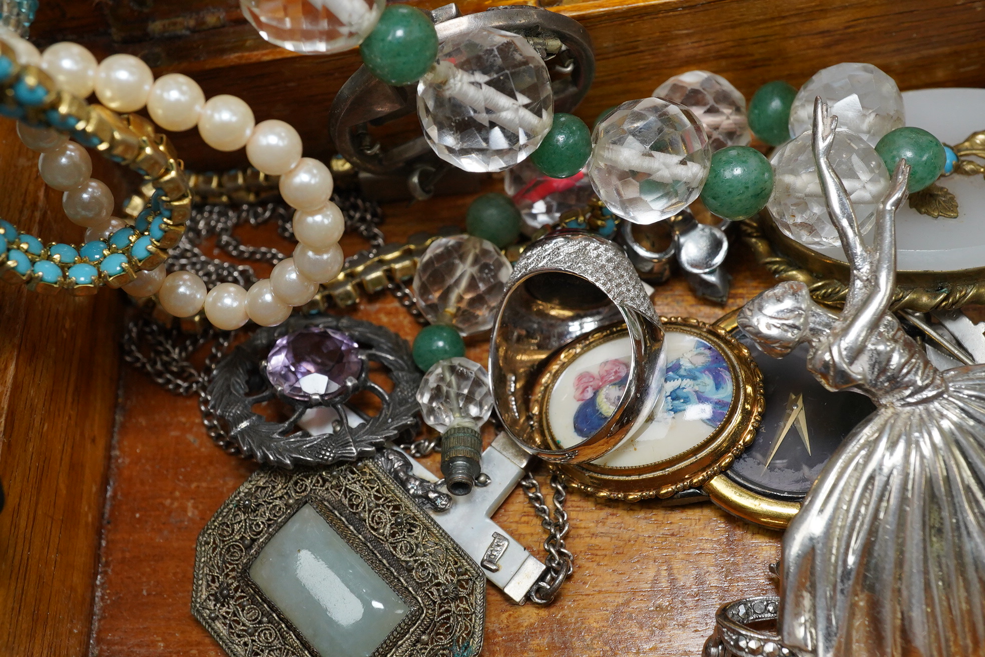 A small quantity of assorted costume jewellery including a Scottish hardstone brooch and a Tiffany & Co. folding silver mirror. Condition - fair to good